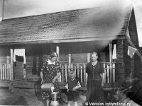 Kerpola(20)  Vasemmalla Kerpolan emäntä Olga Ahlgren (o.s. Peltonen, 12.4.1901 - 12.1.1986) siivilöi maitoa, oikealla seisoo vierailulla oleva Olgan sisko Iida Geijer Vaasasta ja lapsi keskellä on Iidan poika Reino Geijer (1932 - 1993).