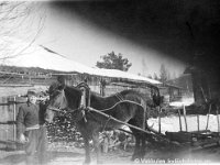 Kerpola(32)  Isäntä Hjalmar Ahlgren  (19.11.1893 - 17.9.1964) kotinsa Kerpolan pihalla, vieressä Sähäkkä-hevonen rekineen, taaempana oikealla toinen tunnistamaton mies (mahdollisesti "Sälli-Eemeli", joka teki paljon töitä Kerpolassa)