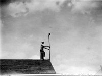 Kerpola(43)  Sune Ahlgren (1922 - 1982) seisoo kotinsa Kerpolan aitan katolla pitäen kiinni tuuliviiristä, ilmeisesti pystyttää sitä.