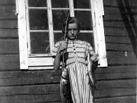Kerpola(44)  Isoveljensä Sunen herättämä Kyllikki Ahlgren (myöhemmin Rantanen, s. 6.12.1927) seisoo kotinsa Kerpolan talon edessä pidellen Sunen aikaisin aamulla Kotijärvestä saamaa kalansaalista, vasemmassa kädessä isoa madetta, oikeassa haukea.