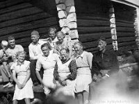 Kerpola(46)  Kerpolan aitan kulmalla istumassa vasemmalta Kerpolan isäntä Hjalmar Ahlgren (19.11.1893 - 17.9.1964) sylissään Kerpolassa asuneen Nion karjalaisen evakkoperheen poika Veijo Nio, sitten Veijon äiti Aili Nio, myös karjalainen evakko Viljo Rokkanen, takana Hjalmarin ja Olgan tytär Kyllikki Ahlgren (myöhemmin Rantanen, s. 6.12.1927), edessä Hjalmarin vaimo Olga Ahlgren (o.s. Peltonen, 12.4.1901 - 12.1.1986) ja Viljo Rokkasen äiti Rokkasen Mamma, Kyllikin vieressä Anna Ampuja, kaksi henkilöä oikealla ovat myös Kerpolassa asuneen Ampujan evakkoperheen jäseniä.