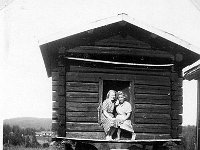 Kerpola(58)  Oikealla Maire Ilkka ja vasemmalla Ahlgrenien kesävieras Vaasasta Marjatta Geijer (myöhemmin Rantamäki, s. 1925 tai 1926) istuvat Kerpolan aitan oviaukolla, taustalla maisemassa näkyy naapuritalo Järvenpää (aiempi nimi Lepsala).