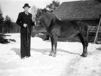Kerpola(62)  Sune Ahlgren (1922 - 1982) puku päällä hattu päässä pitelee Sähäkkä-hevosta ohjaksista lapsuudenkotinsa Kerpolan pihassa.