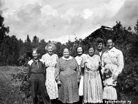 Image25  Leuhulan vanhan pirtin puutarhan takana Leuhulan ja Kopoon perheet: Vasemmalta Pauli Mäki (s. 24.6.1939), äitinsä Siiri Dagmar Martikainen (entinen Mäki, o.s. Tähtinen, 12.9.1907 - 1999?), Siirin äiti Lydia Kovanen (o.s. Tähtinen, lapsuudessa sukunimi Leuhula), sitten mahdollisesti Katrin tytär Kaija Hienola (myöhemmin Routio, avioeron jälkeen jälleen Hienola, s. 1934), Lydian toinen tytär Katri Hienola (o.s. Tähtinen) eli Kopoon Kaisa, Siirin toinen aviomies Väinö Martikainen, ja Katrin aviomies Viljo Hienola eli Kopoon Ville. Viljon edessä Hienoloiden nuorin tytär Helena (myöhemmin Sillanpää).